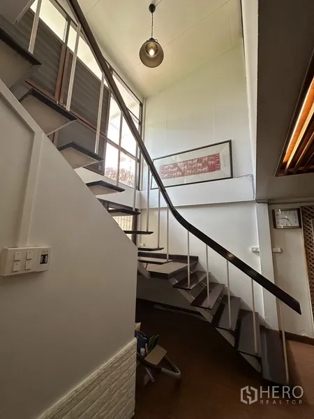 Detached House for rent in Watthana, Bangkok - Staircase with metal handrail, high ceiling and large window allowing natural light.
