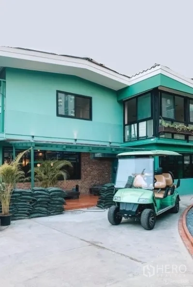 Detached House for sale in Khlong Toei, Bangkok - Two-storey mint-green detached house with corner glass room, wide driveway and a golf cart in Ekkamai, Bangkok.