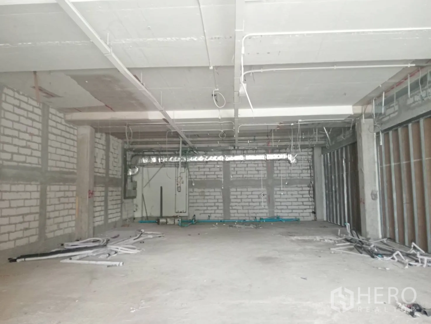 Retail Space for rent - Large shell retail interior with masonry walls, exposed ceiling ducts, and concrete floor.