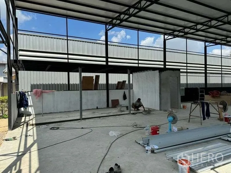 Warehouse for rent in Mueang Pathum Thani, Pathum Thani - Partially built internal room and utilities within the steel-structure warehouse.