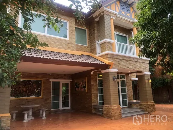 Detached House for rent or sale in Pak Kret, Nonthaburi - Front entrance with covered carport, balcony and decorative columns.