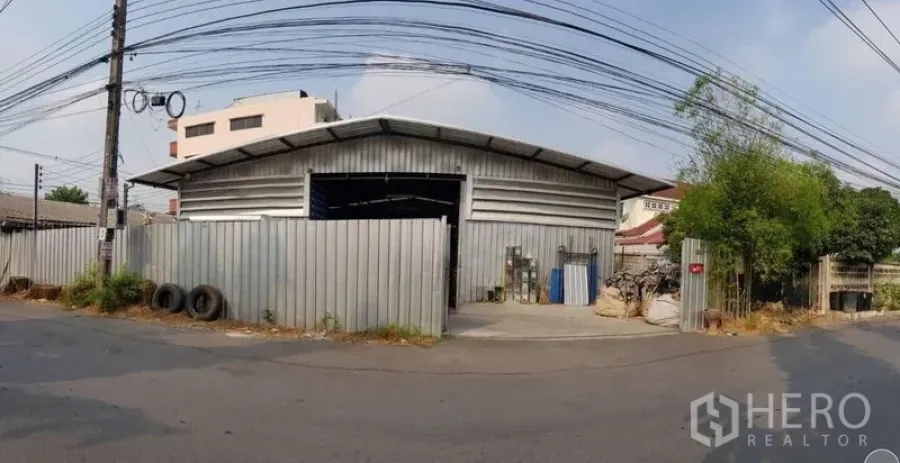 Warehouse for rent in Sai Mai, Bangkok - Wide-angle view of the street-facing warehouse facade with sliding gate and secure boundary.