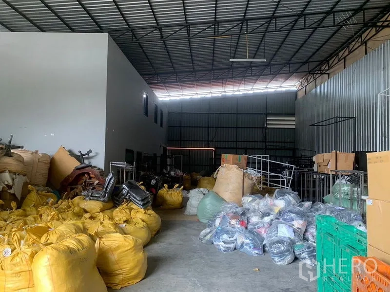 Warehouse for rent in Bang Kapi, Bangkok - Spacious warehouse interior with high ceiling, steel trusses and open concrete floor for storage.