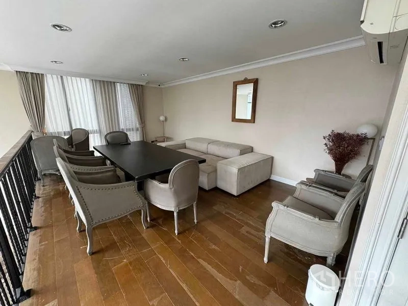 Townhouse for rent in Watthana, Bangkok - Mezzanine lounge with dining table and classic armchairs overlooking the living area.