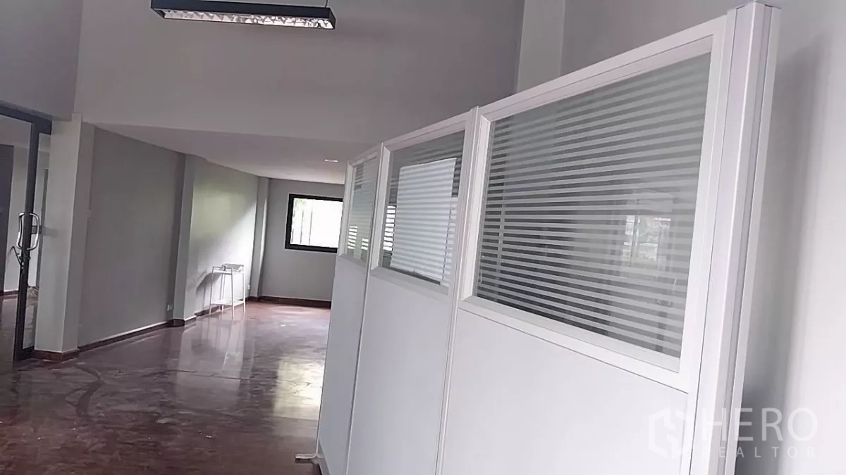 Retail Space for rent - Long corridor-style area with glossy floors and white partitions with blinds.