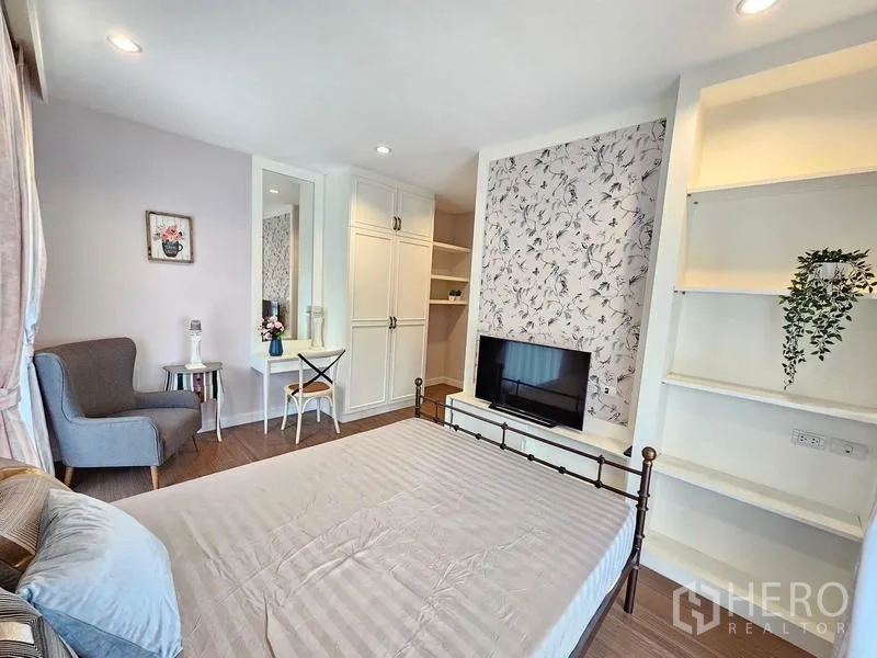 Detached House for rent in Prawet, Bangkok - Master bedroom view with TV, white built-in cabinets, and shelving.