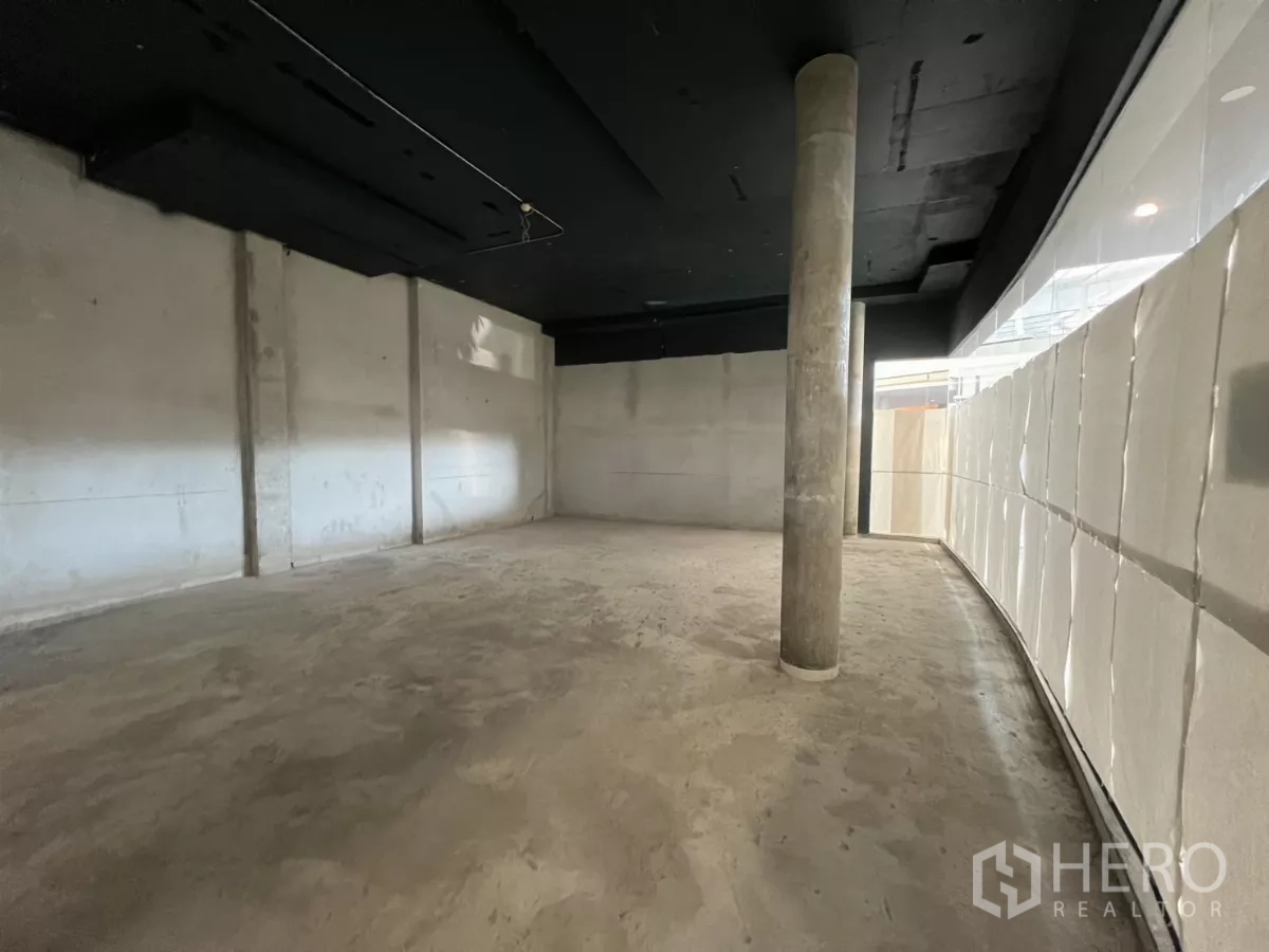 Retail Space for rent - Spacious open-plan area with structural column and long curved glazed frontage ready for fit-out.