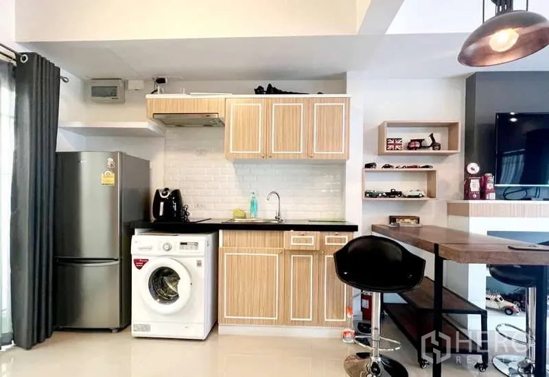 Detached House for rent in Bang Phli, Samut Prakan - Compact kitchen with wood cabinets, black countertop, fridge and washing machine.