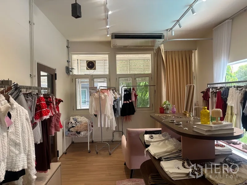 零售空间 for rent in Khlong Toei, Bangkok - 店内一角可见绿意窗景、空调、衣架与展示台面。