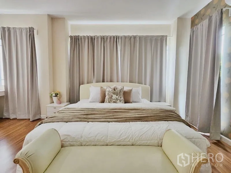 Detached House for rent in Prawet, Bangkok - Close-up of the master bed with neutral curtains and layered bedding.