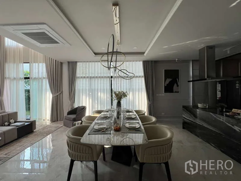 独立式住宅 出售在Suan Luang, Bangkok - 餐区连厨房，造型吊灯与高窗帘