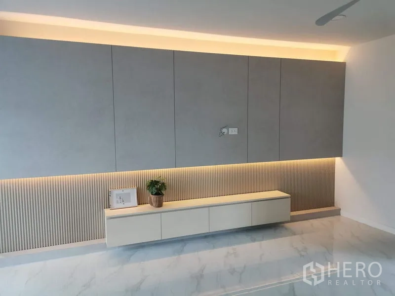 Townhouse for rent in Bang Phli, Samut Prakan - Built-in TV console wall with soft LED lighting and minimalist cabinetry.