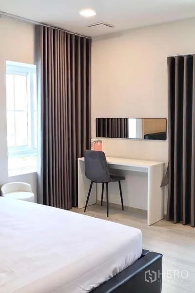 Detached House for rent in Bang Phli, Samut Prakan - Bedroom workspace with white desk, chair and tall blackout curtains.