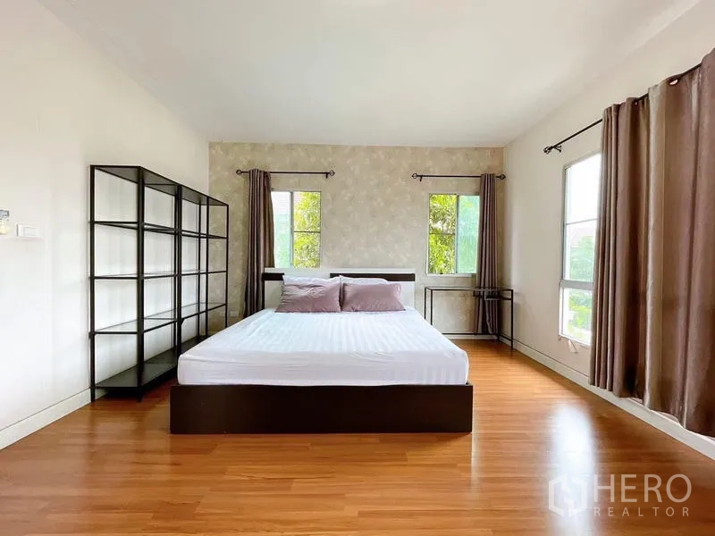 Detached House for rent in Bang Na, Bangkok - Spacious master bedroom with wood floors, corner windows and double bed.