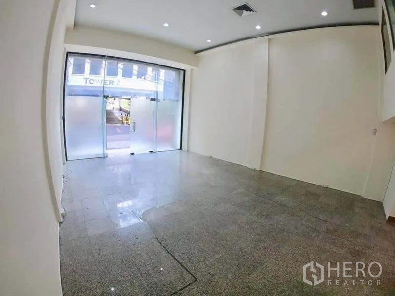 Office Space for rent in Khlong Toei, Bangkok - Ground-floor office area with frosted glass storefront doors and polished floor.