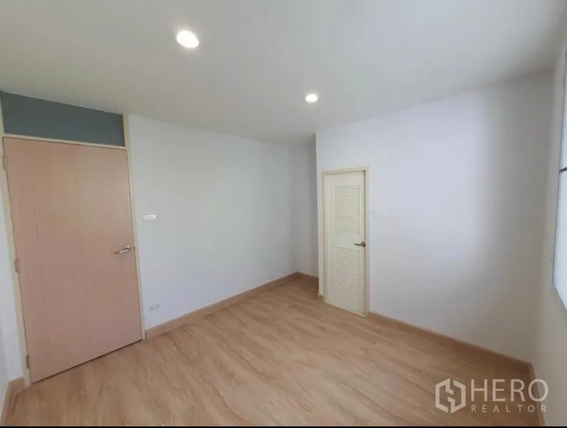 Townhouse for rent in Phaya Thai, Bangkok - Compact bedroom or study with louvered closet door and bright walls.