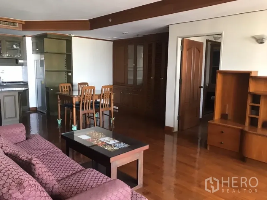 Condominium for rent in Watthana, Bangkok - Open-plan living and dining area with built-in cabinetry and wooden floors.