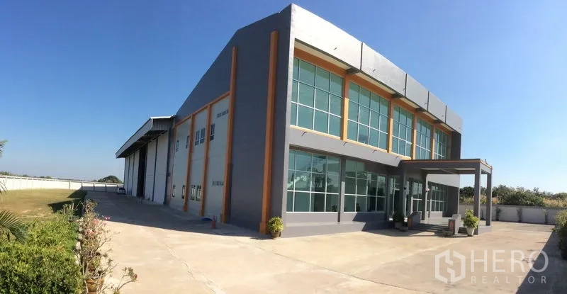 Factory for sale in Bang Sao Thong, Samut Prakan - Wide view of the factory building with large concrete apron and landscaped verge.