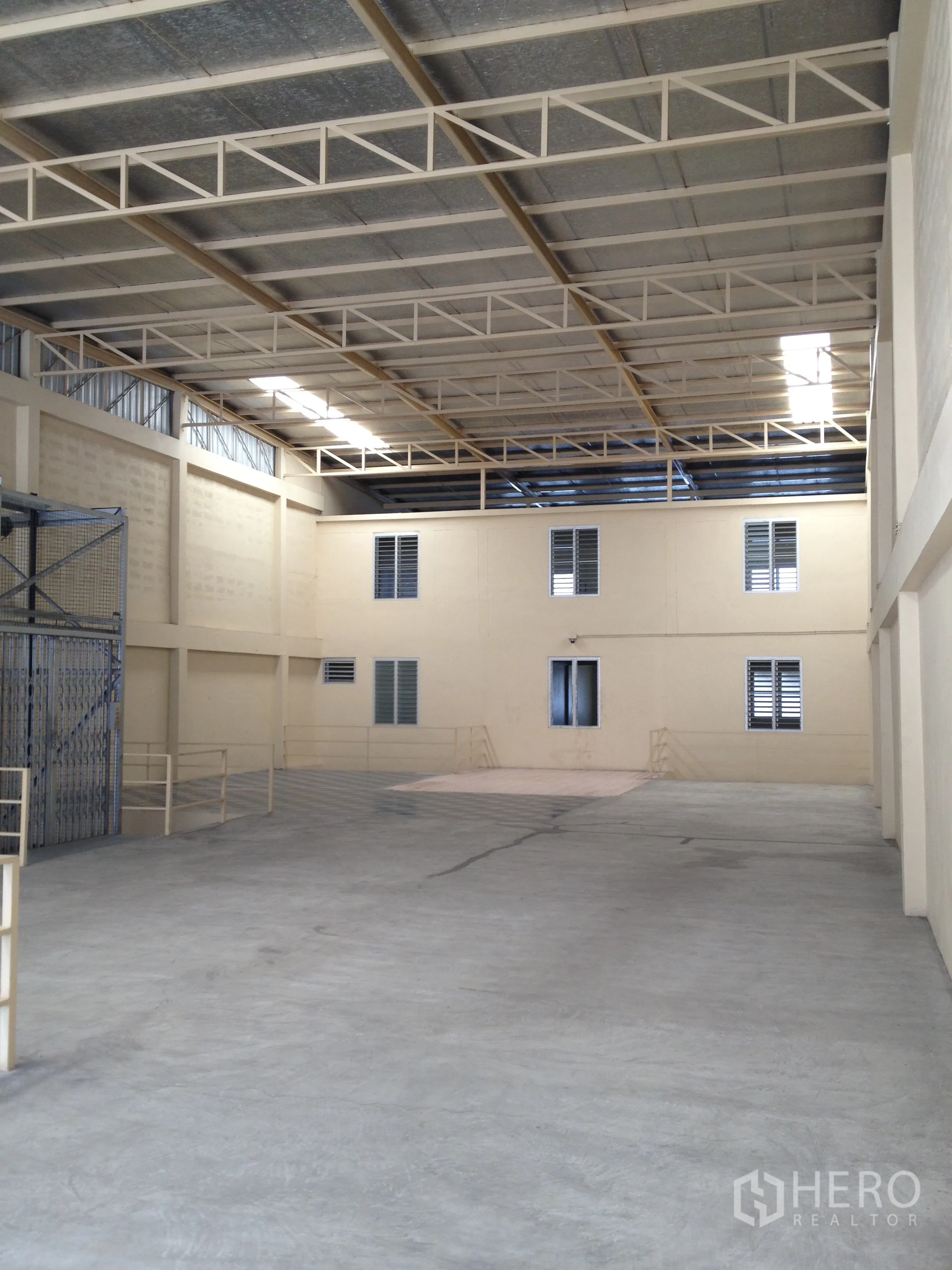 Factory for rent in Thung Khru, Bangkok - High-span warehouse interior with insulated roof and raised platform rooms.