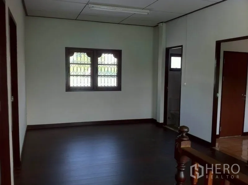 货栈 出租在Lam Luk Ka, Pathum Thani - 宽敞二层房间，带护栏窗与通往卫浴的门。