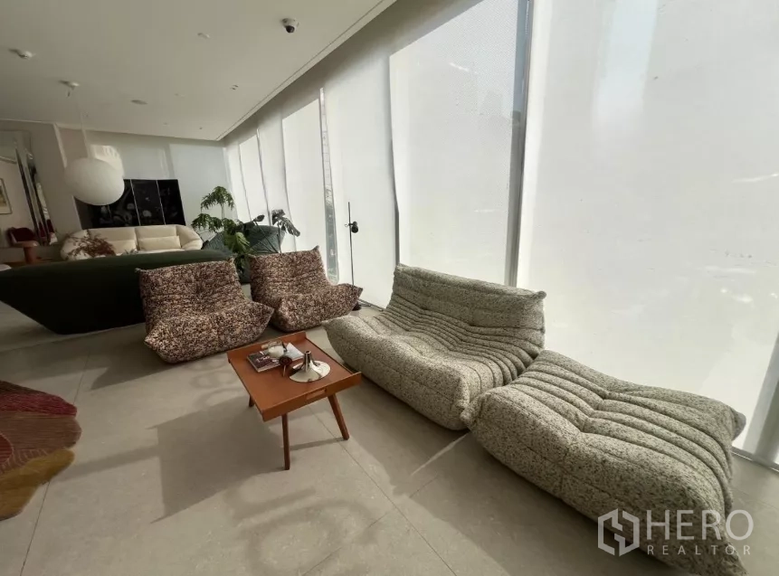 Retail Space for rent - Cozy seating nook with low sofas by tall windows.