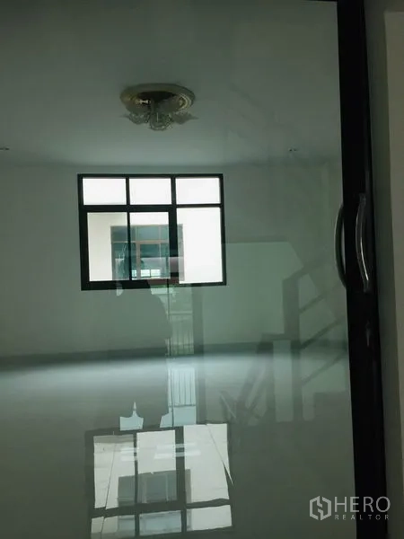 Home Office for rent in Wang Thonglang, Bangkok - Empty bright room with square window and glass door reflecting polished flooring.