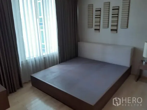 Condominium for rent in Khlong Toei, Bangkok - Cozy bedroom with platform bed frame, large window, sheer and blackout curtains.