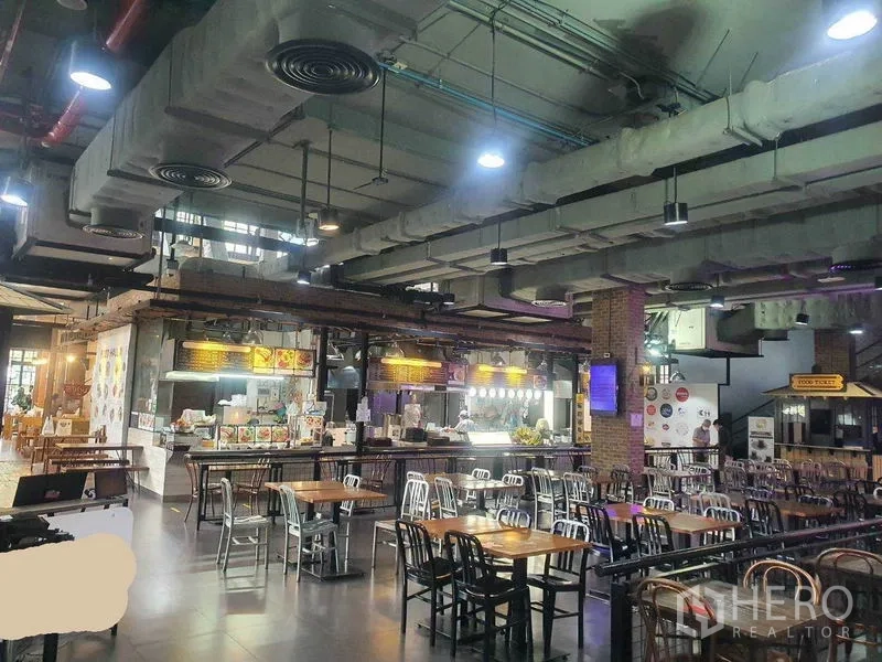 Retail Space for rent in Khlong Toei, Bangkok - Industrial-style retail interior with high ceilings, exposed ducts, pendant lights and rows of dining tables in the Phrom Phong area of Bangkok.