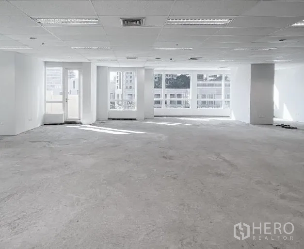 Office Space for rent - Spacious office room with wide windows and a glass door bringing natural light.