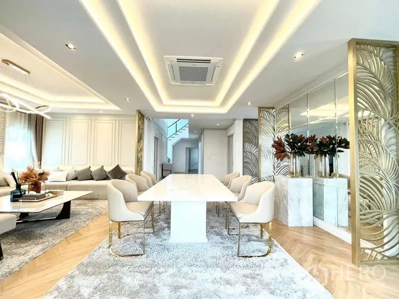 Detached House for rent in Bang Phli, Samut Prakan - Contemporary dining area with white table, upholstered chairs and mirrored wall.