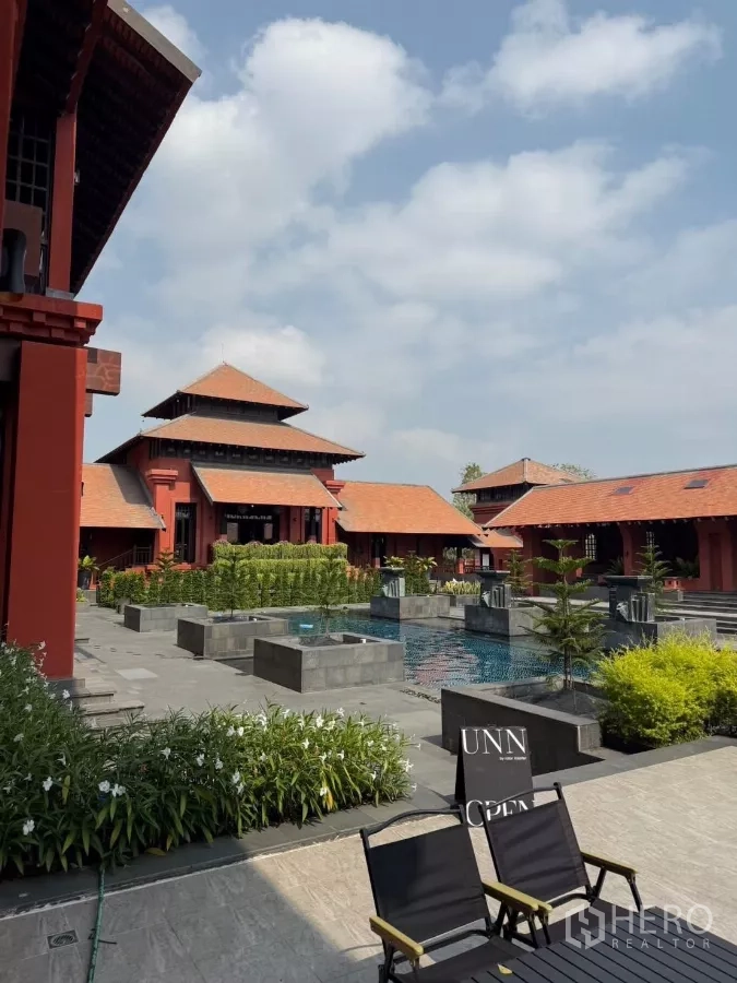 Detached House for rent or sale in Mueang Nonthaburi, Nonthaburi - Communal swimming pool and landscaped courtyard beside red-roofed clubhouse.