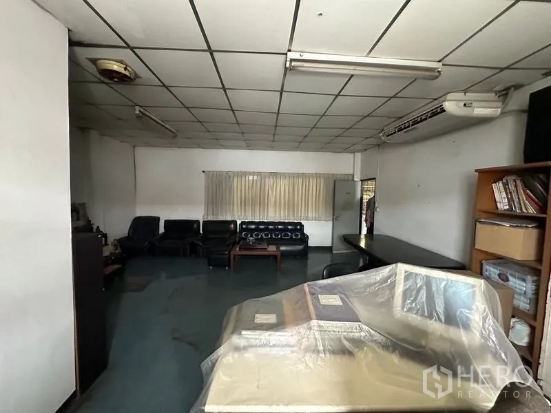 Factory for rent in Lam Luk Ka, Pathum Thani - Large office lounge with sofas, ceiling air-conditioning, and shelving.