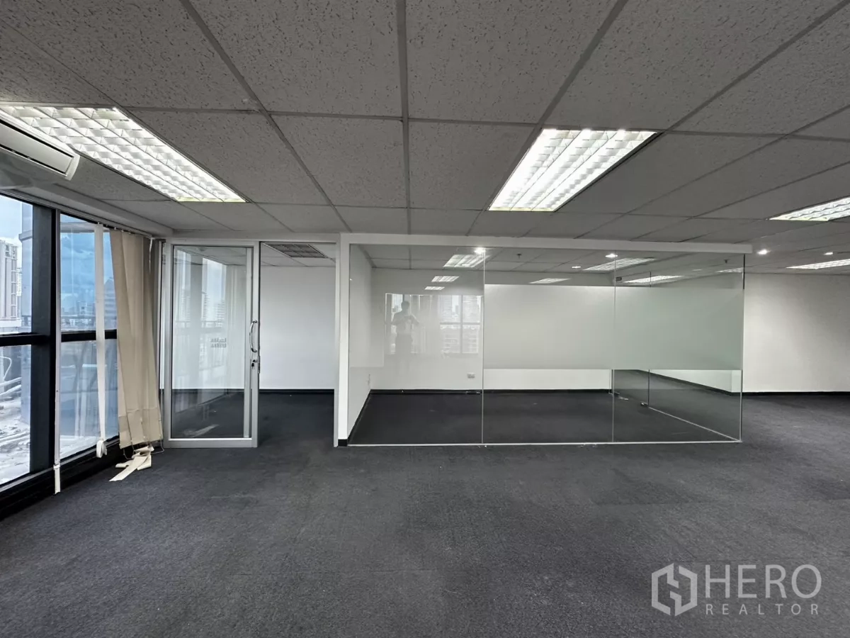 Office Space for rent in Watthana, Bangkok - Corner workspace with split-type air conditioner, floor-to-ceiling windows, and glass partitions.