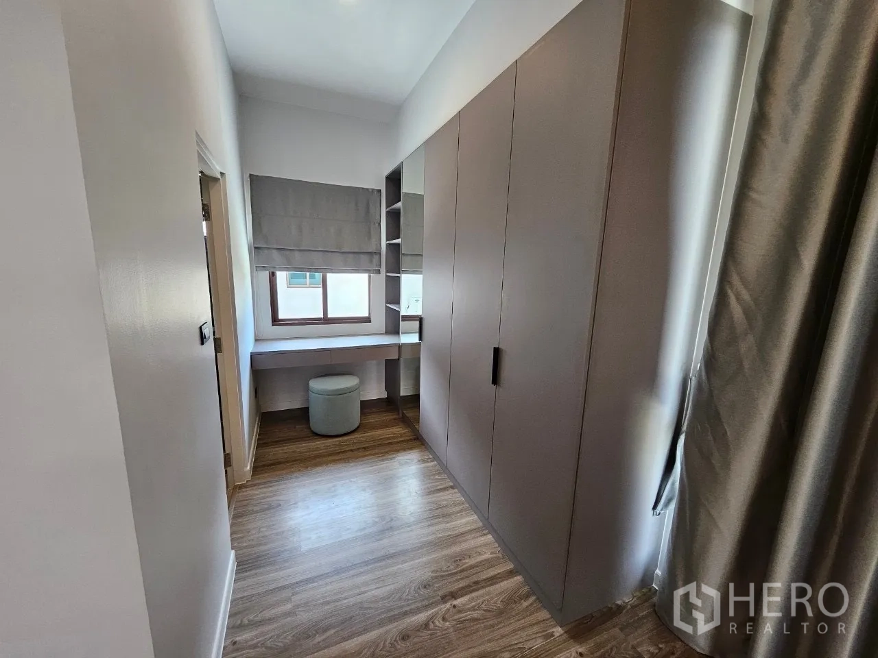 Detached House for rent in Bang Kapi, Bangkok - Walk-in closet corridor with fitted wardrobes and a dressing desk.