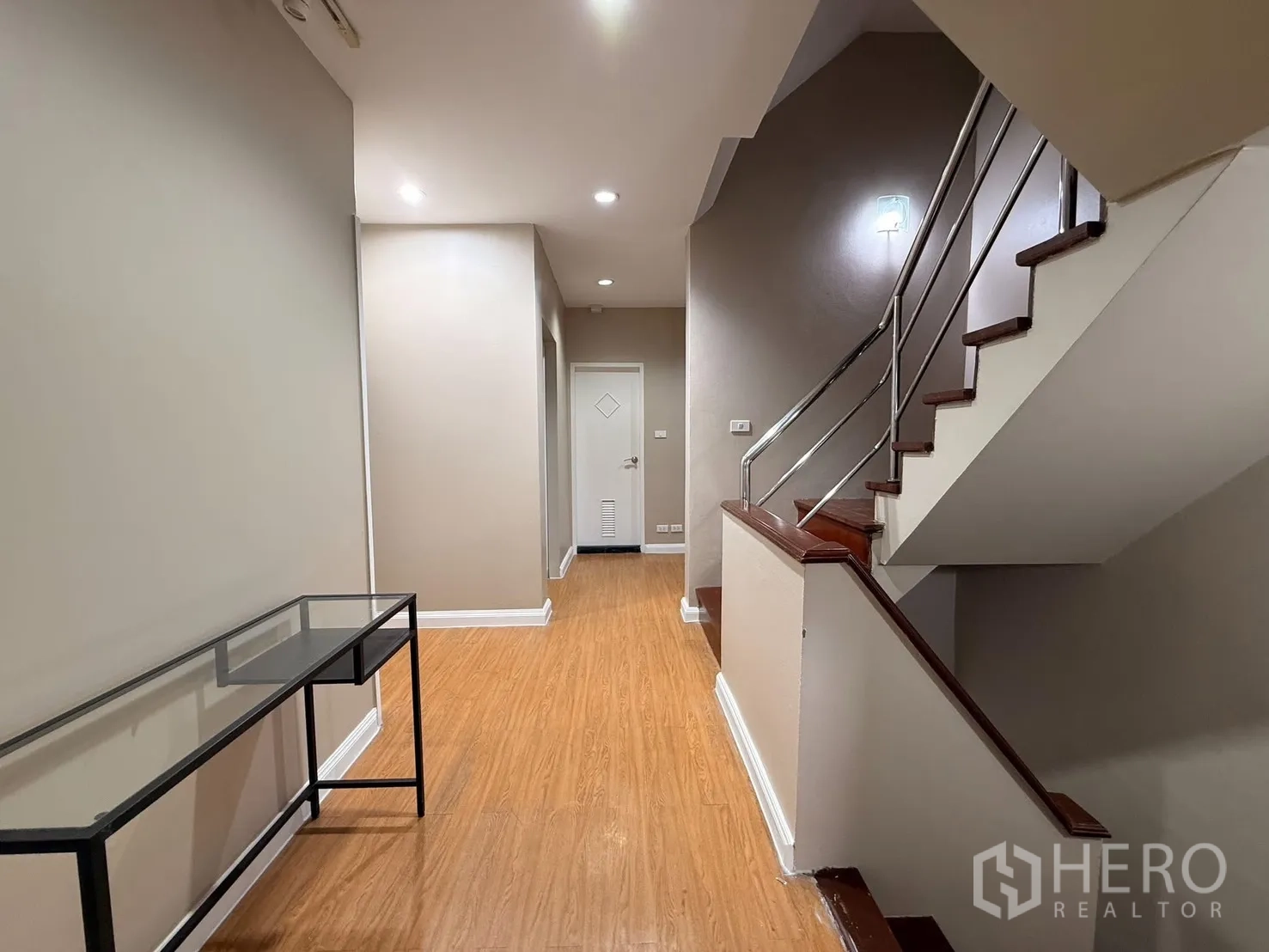 Home Office for rent in Wang Thonglang, Bangkok - Hallway with wooden steps, metal handrail and a slim console table.