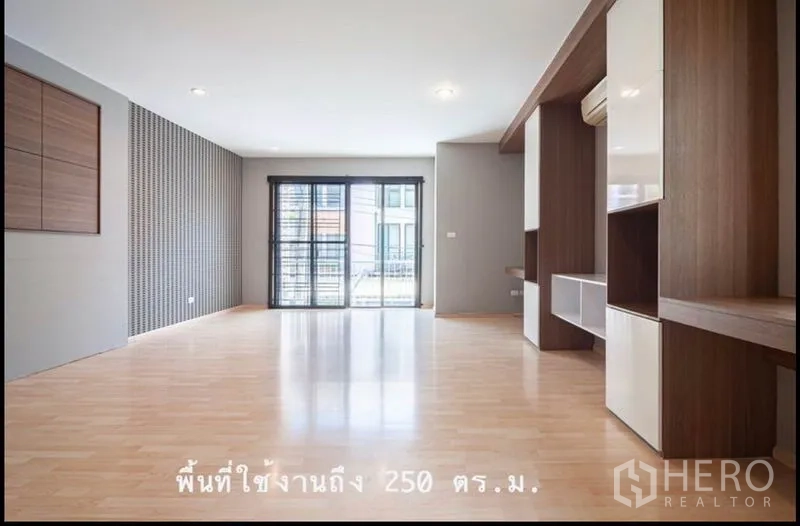 Townhouse for sale in Khlong Toei, Bangkok - Spacious multi-purpose family room with light wood floors, built-in shelves and balcony doors.