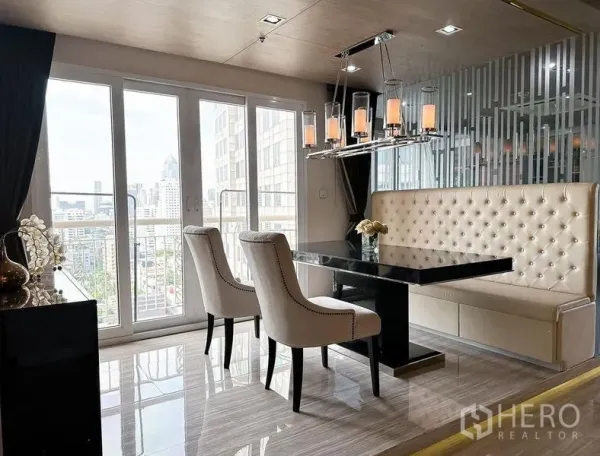 Condominium for rent or sale in Khlong Toei, Bangkok - Dining nook with tufted banquette seating, black table and balcony doors.