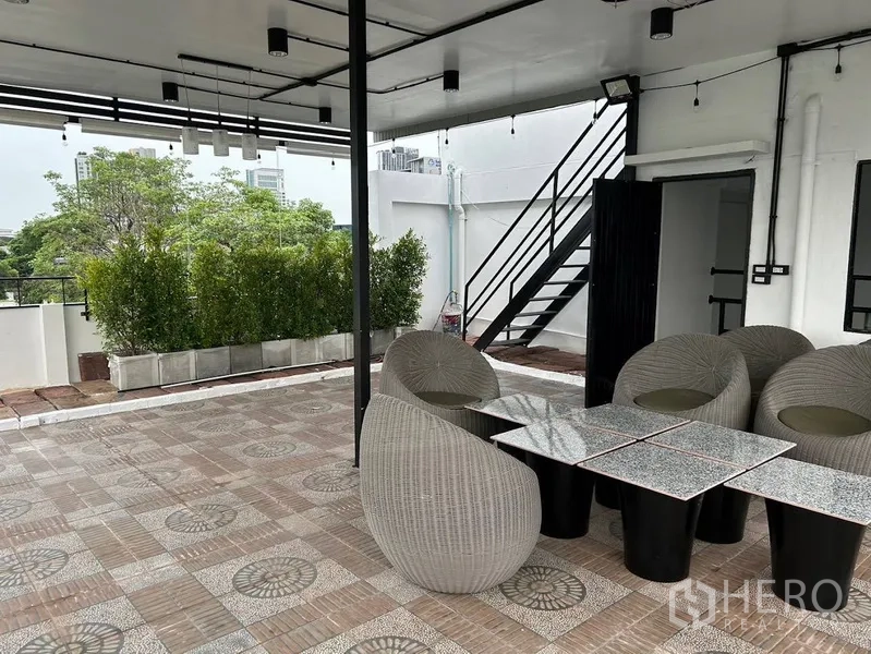 Home Office for rent or sale in Phra Khanong, Bangkok - Covered rooftop terrace with outdoor seating, planters and open city views.