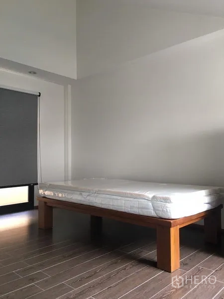 联排别墅 出租在Khlong Toei, Bangkok - 简洁卧室，单人床与仿木地板。