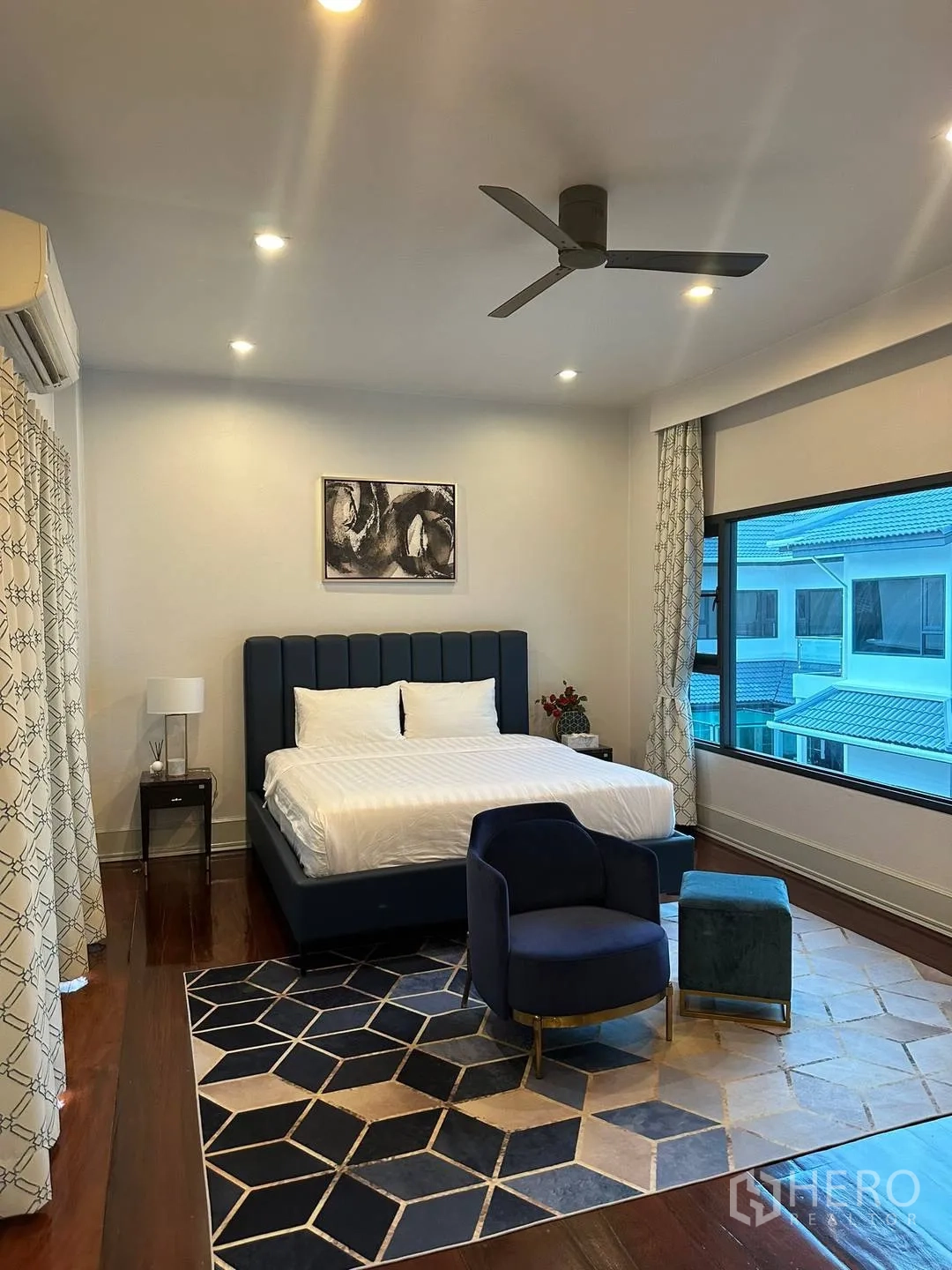 Detached House for rent in Watthana, Bangkok - Bedroom with blue headboard, armchair and geometric rug.