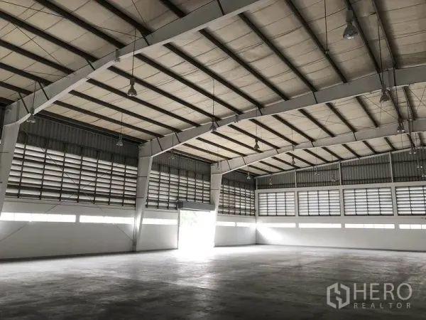 Factory for rent in Bang Pa-in, Phra Nakhon Si Ayutthaya - Warehouse interior with roller shutter door, louvered ventilation and bright lighting.