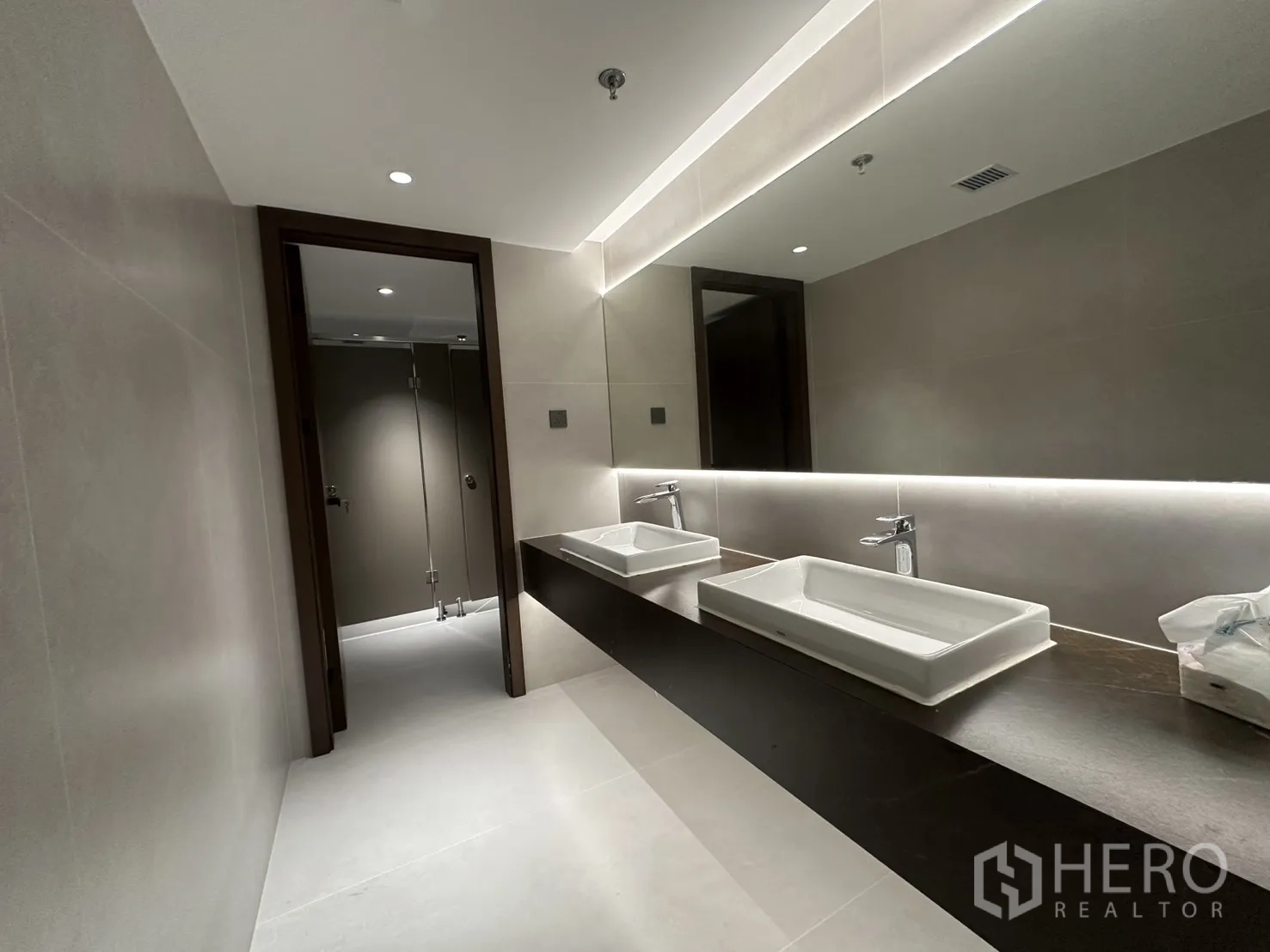 Office Space for rent in Din Daeng, Bangkok - Modern restroom with double rectangular basins and a long backlit mirror.