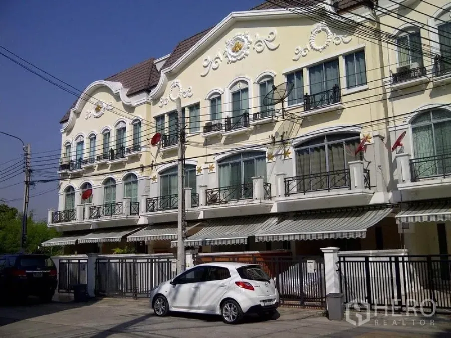 Home Office for rent or sale in Suan Luang, Bangkok - Three-storey European-style townhouse facade with small balconies and gated parking.