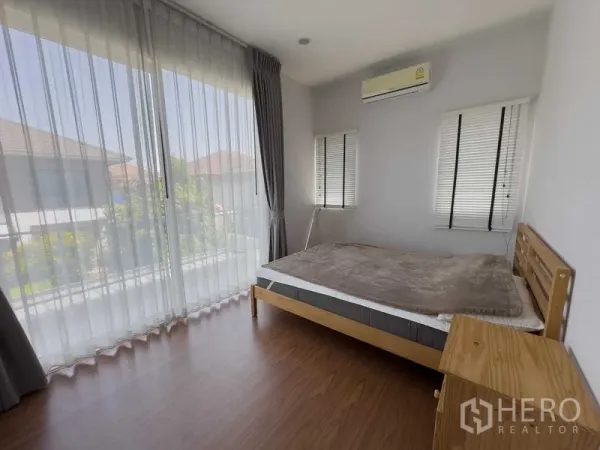 Detached House for rent or sale in Bang Khen, Bangkok - Bright corner bedroom with large glass wall, balcony outlook and air conditioning.