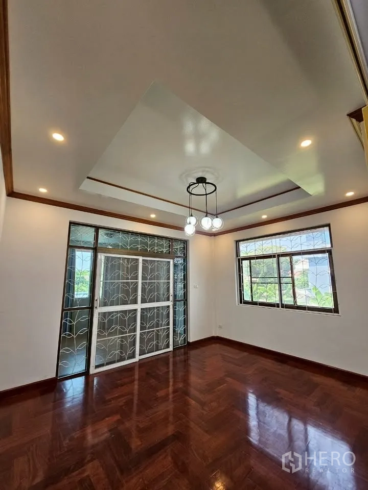 Home Office for rent in Wang Thonglang, Bangkok - Room with pendant chandelier, sliding glass door with decorative grilles, and hardwood floors.