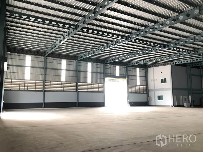 Factory for rent in Bang Len, Nakhon Pathom - Industrial space with tall windows, ventilation louvres and front shutter entrance.