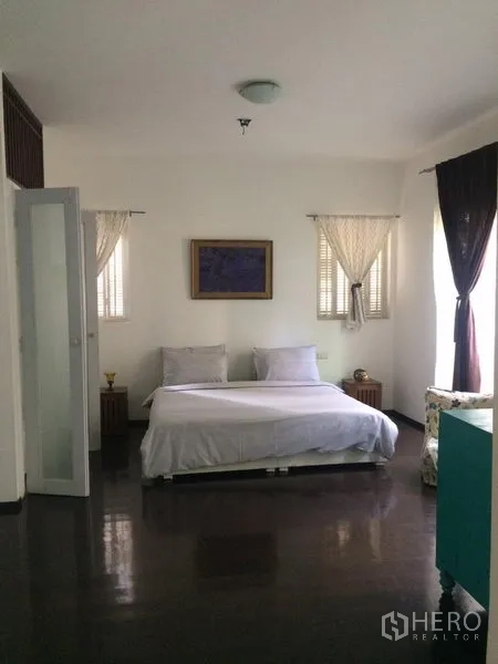 独立式住宅 出租在Sathon, Bangkok - 明亮卧室，双人床、纱帘与抛光深色木地板。