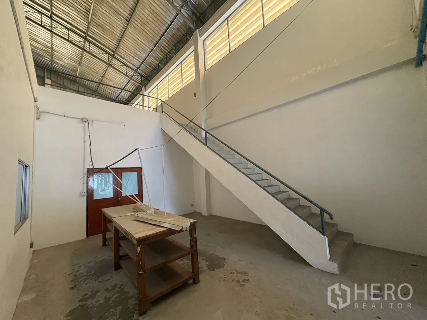 Warehouse for rent in Bang Phli, Samut Prakan - Workshop area with staircase to upper level and high side windows.