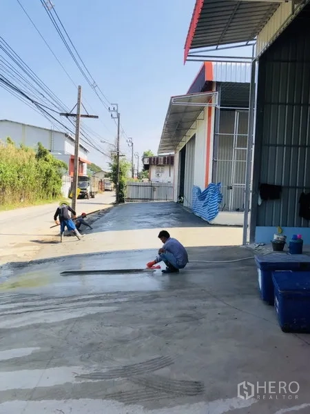 Warehouse for rent in Bang Kapi, Bangkok - Covered loading area and warehouse entrance with fresh concrete slab beside a local road in Bang Kapi.