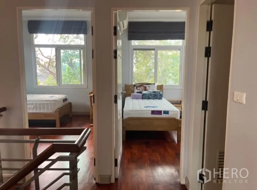 独立式住宅 出租或出售在Lat Phrao, Bangkok - 二楼走廊通往卧室，木地板与大窗。